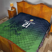 Green and dark blue quilt on bed with custom text, crest logo, and number 21