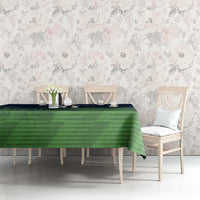 Green patterned cricket tablecloth draped over rectangular dining table