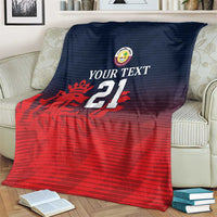 Custom Qatar cricket blanket on armchair, red and navy sporty graphic with crest and 21