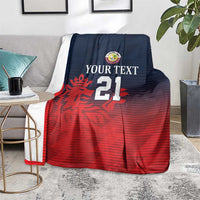 Custom Qatar cricket blanket on couch, navy top and red bottom with crest and 21
