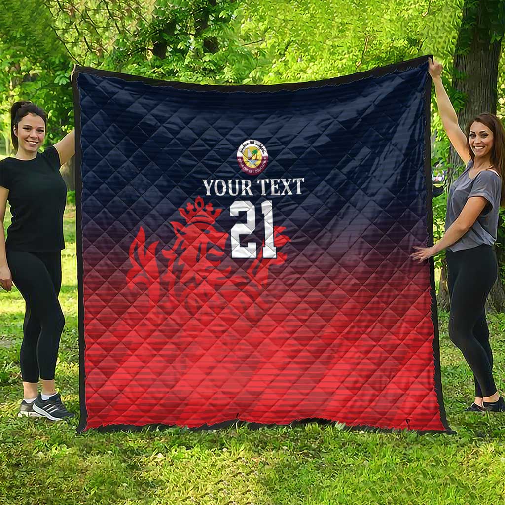 Cricket quilt laid flat outdoors with navy top, red bottom, crest, flame graphic, number 21