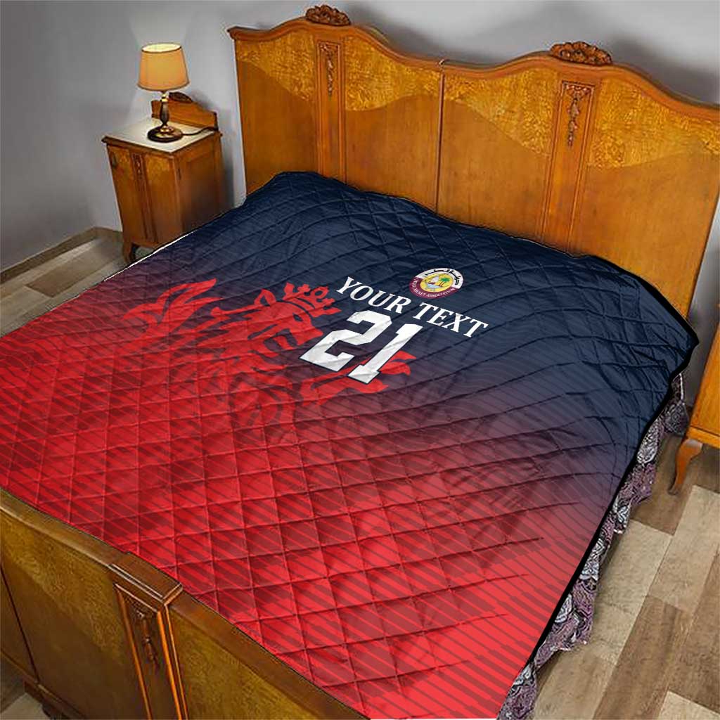 Cricket quilt on bed with navy quilted top, red lower half, crest, flames and number 21