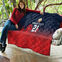 Cricket quilt held up with navy quilted top, red bottom, crest, flame graphic and 21