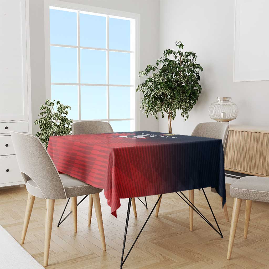 Red and dark blue sports tablecloth draped over dining table with matching chair set.