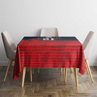 Red sports tablecloth with textured striped pattern on square table between four chairs.