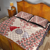 Quilt bed set with cream quilt, red folk motifs, black trim, and two patterned pillow shams