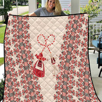 Quilted throw blanket with beige base and red vertical folk border panels