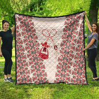 Large quilted blanket with beige center panel and red folk pattern stripes along edges