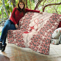 Quilted blanket with beige background, red patterned stripes, and central ribboned heart design