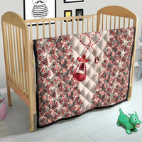 Quilted baby blanket for crib with beige fabric, red folk borders, and heart motif