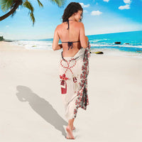 Beige patterned sarong tied at waist with red-and-black stripes and motifs