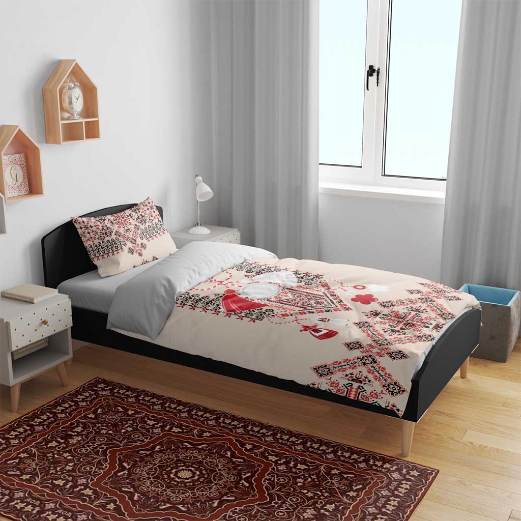 Beige duvet cover with red and blue traditional embroidery motif on a bed with two pillowcases