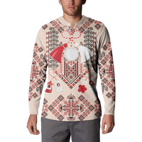 Beige long-sleeve sweatshirt on model, with folk print and red heart emblem