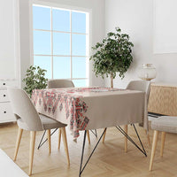 Beige tablecloth with red and navy folk embroidery pattern covering dining table