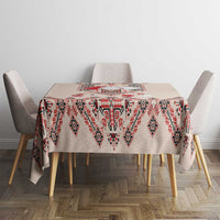 Beige tablecloth with red, navy, and white folk embroidery diamond pattern on dining table