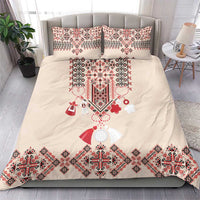 Beige duvet and two pillowcases with red-and-blue folk embroidery border and motifs