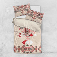 Beige bedding set shown folded: duvet and two pillowcases with red folk embroidery