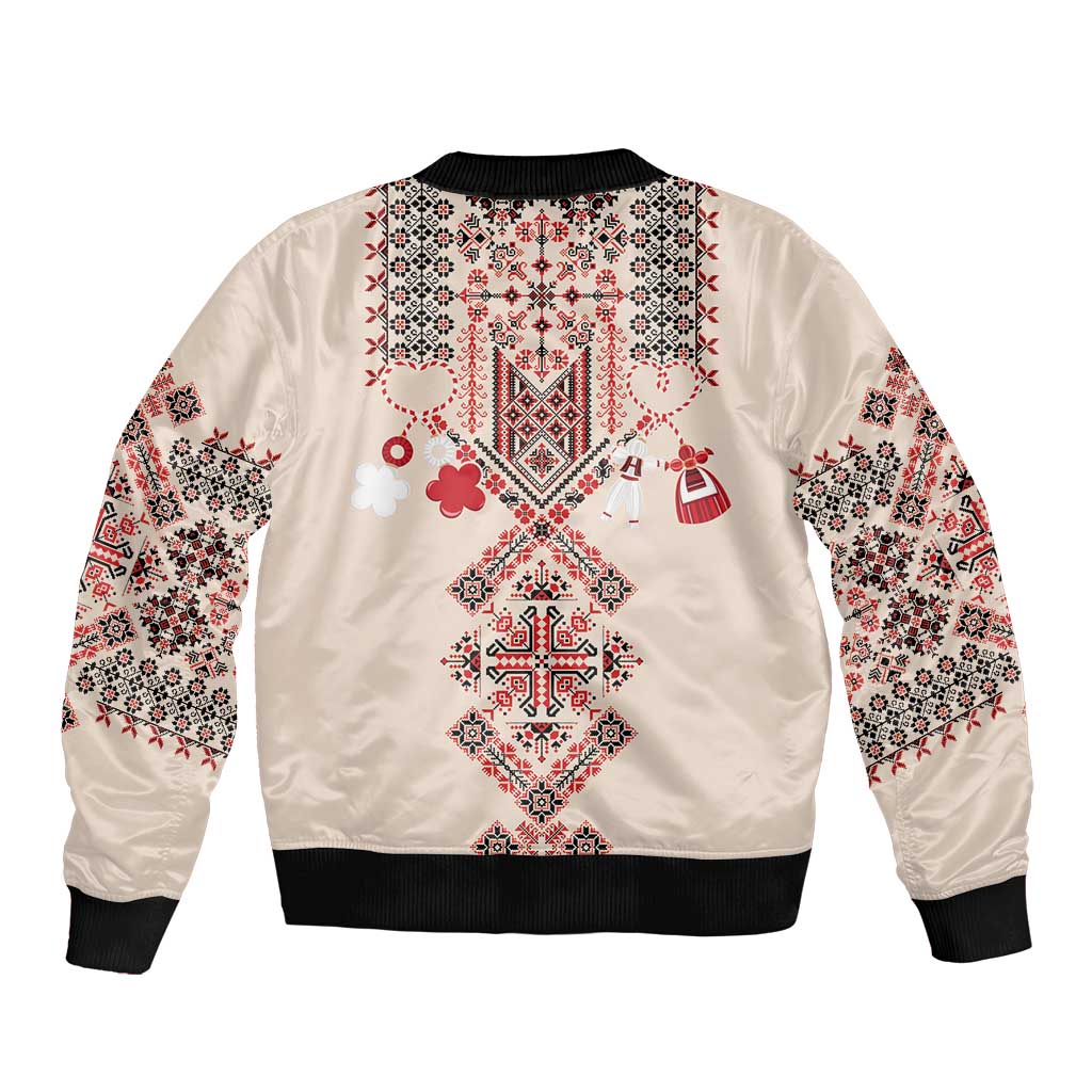 Beige bomber jacket back with colorful folk embroidery and black ribbed hem, full sleeves.