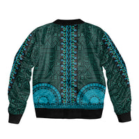 Teal bomber jacket with all-over tapa pattern, vertical embroidered stripe, and ribbed hem.