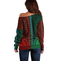 Back of off-shoulder dashiki-style sweater in green and red with blue trim