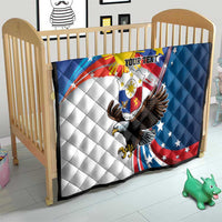 Personalized quilt on baby bed with quilted pattern, eagle emblem, and “YOUR TEXT”