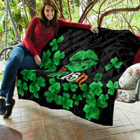 Black quilt with green clovers and Irish-themed center text, laid out outdoors.