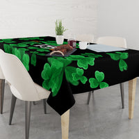 Black tablecloth with green clover-leaf pattern draped over dining table
