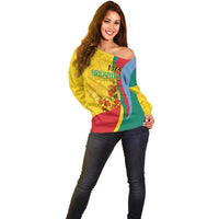 Women’s off-shoulder sweater, yellow front with Grenada flag design and 1974 emblem