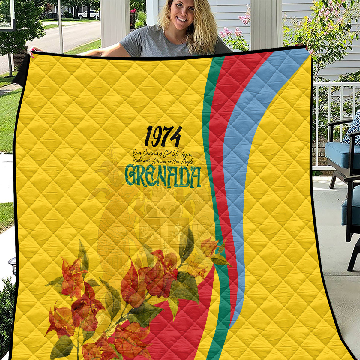 Yellow quilt with quilted diamond pattern, Grenada 1974 text, flag-style red/blue curve and flowers