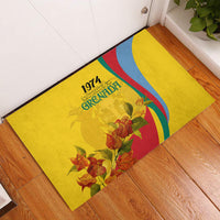 Yellow rubber doormat with Grenada 1974 text, flag-style stripes, and red orange flowers