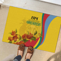 Yellow rubber doormat with Grenada 1974 text and red orange floral design, flag-style stripes