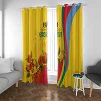 Yellow Grenada flag-style window curtains with bougainvillea flowers and vertical red, green, blue stripes.