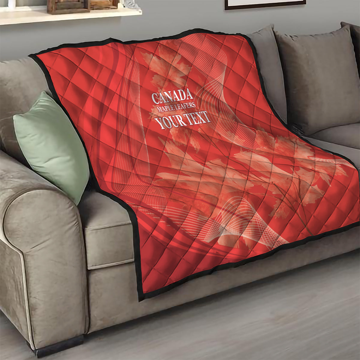 Red quilt over sofa with diamond quilting and white 'CANADA MAPLE LEAFERS YOUR TEXT' print