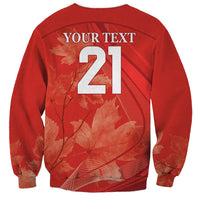 Red crewneck sweatshirt back with large 21 number and maple leaf graphic