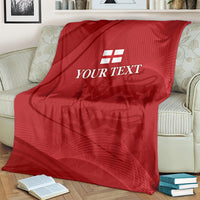 Red cricket blanket with white England emblem and 'YOUR TEXT' on an upholstered chair