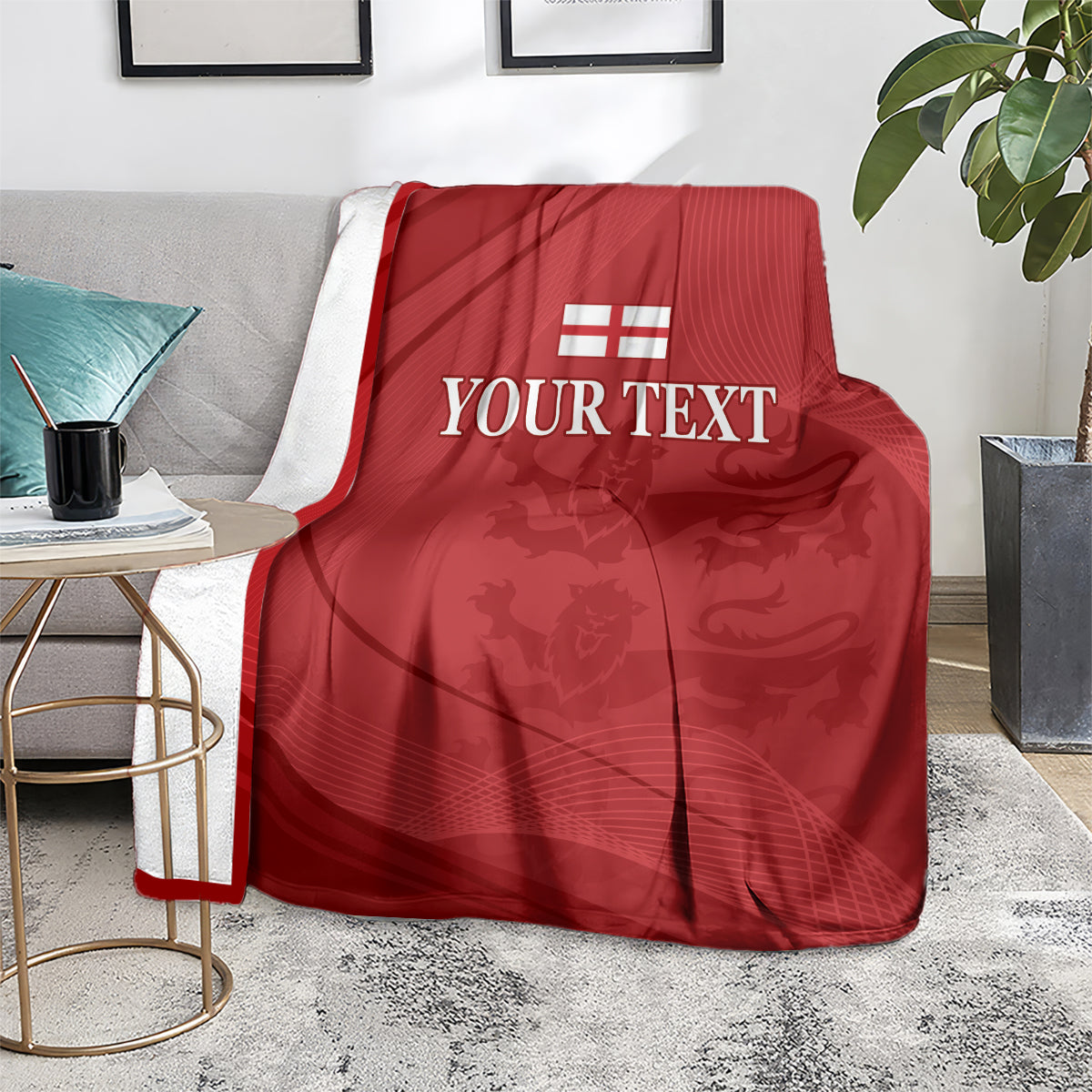 Red cricket blanket with white England emblem and 'YOUR TEXT' on a gray sofa