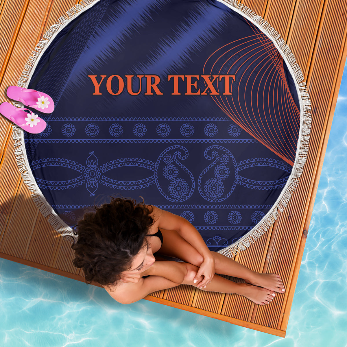 Blue round beach blanket with white fringe, patterned design and 'YOUR TEXT' print