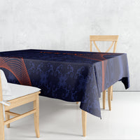 Blue tablecloth with dark geometric and floral motifs and orange-red wave lines