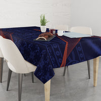 Blue tablecloth draped on dining table with orange-red swirls and dark floral pattern