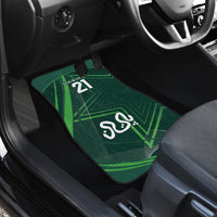 Green car floor mat with '21' and Arabic emblem, driver-side close-up