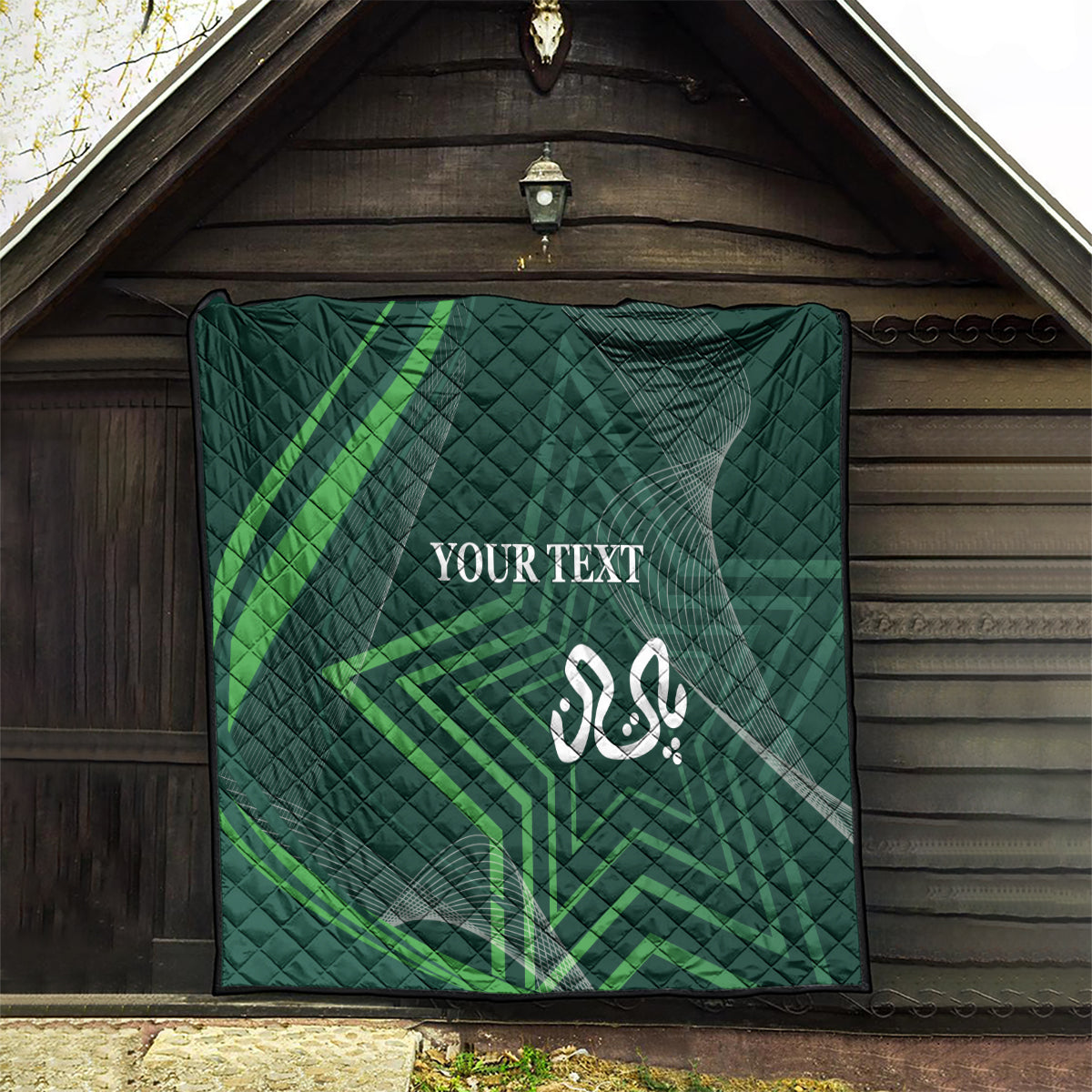 Green quilt with diamond quilting, green geometric lines, and white Arabic-style emblem