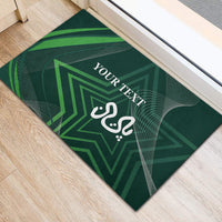 Green rubber doormat, angled view, with geometric star and white 'YOUR TEXT' in center