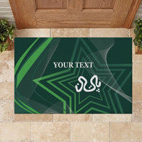 Green rubber doormat rectangle with geometric star graphic and white 'YOUR TEXT' and emblem