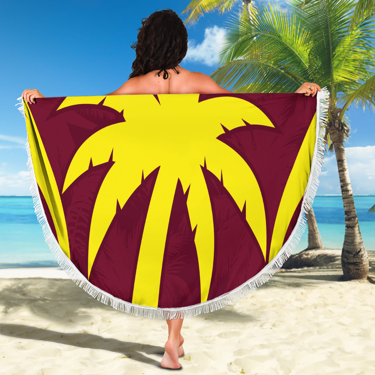 Maroon round beach blanket with yellow palm design and white fringe trim.