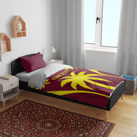 Maroon and yellow palm print duvet set with two pillows on a bed