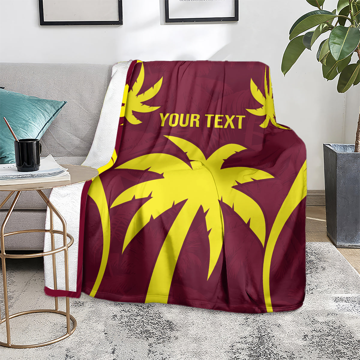 Maroon blanket with yellow palm design and "YOUR TEXT" over a light-gray couch