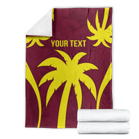 Maroon blanket folded with yellow burst pattern and "YOUR TEXT", beside stacked white towels