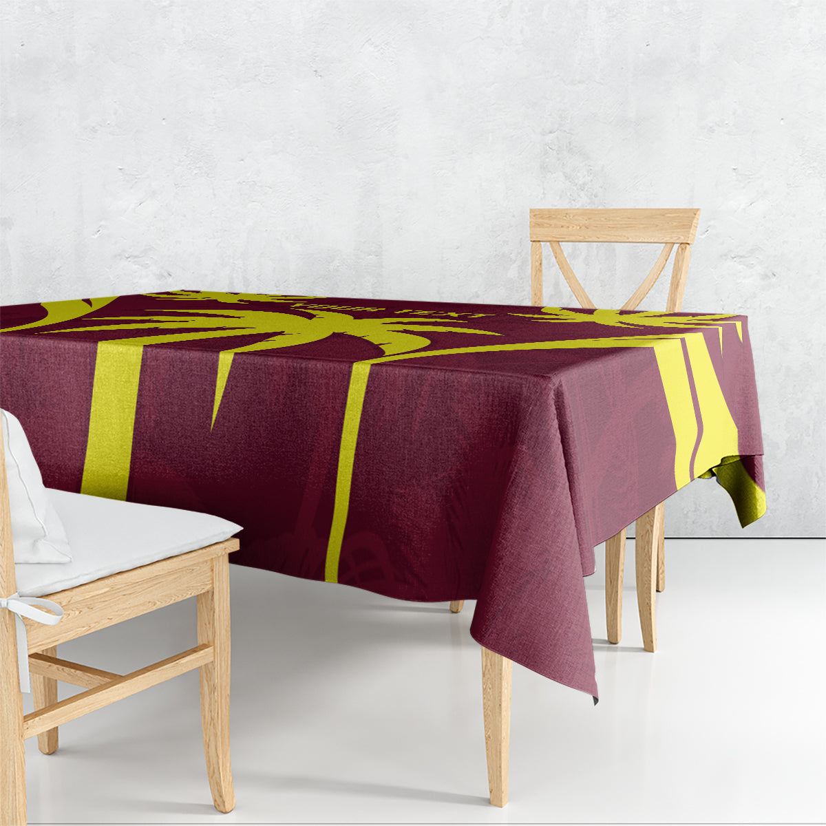 Maroon and yellow cricket-themed tablecloth draped on bench table, corner detail