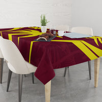 Maroon and yellow tablecloth with bold sunburst stripes over a rectangular dining table