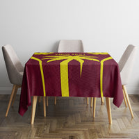 Maroon and yellow cricket tablecloth with large blocky graphic design on square table